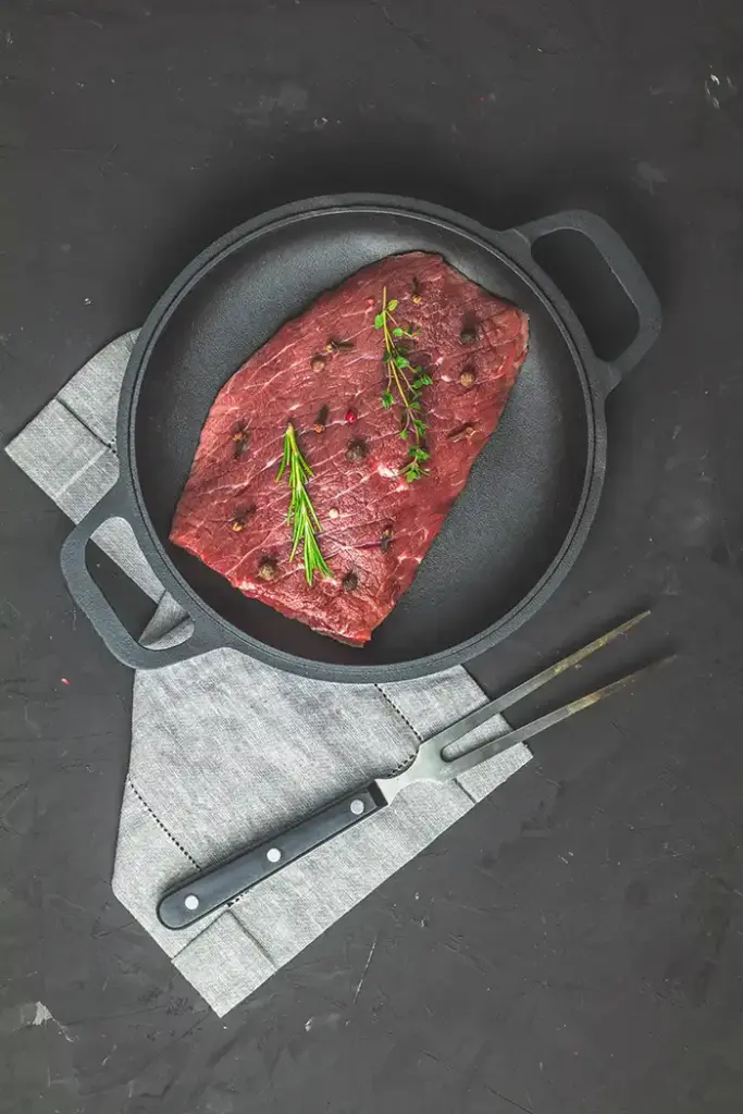 flanksteak-zubereiten-rohes-flanksteak-pfanne-rosmarin-thymian Flanksteak zubereiten - rohes Flanksteak in Gusseisenpfanne mit Rosmarin und Thymian
